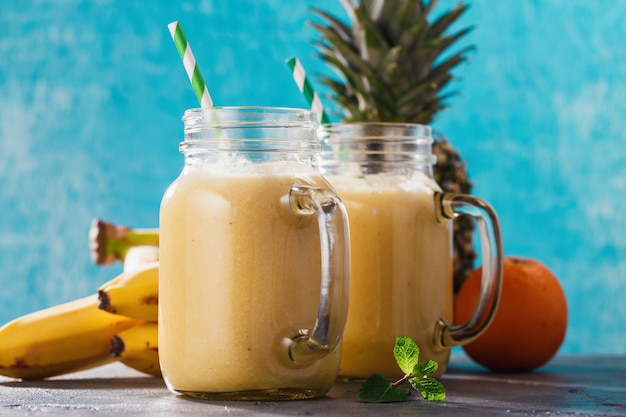 Smoothies of pineapple banana and orange in a glass jar