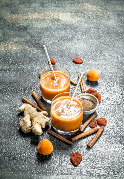 Smoothies with dried fruits, ginger and cinnamon. On rustic background.