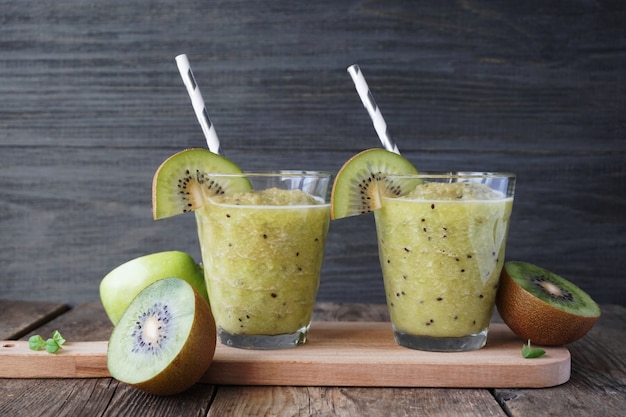 Smoothies with kiwi and apple on a wooden table