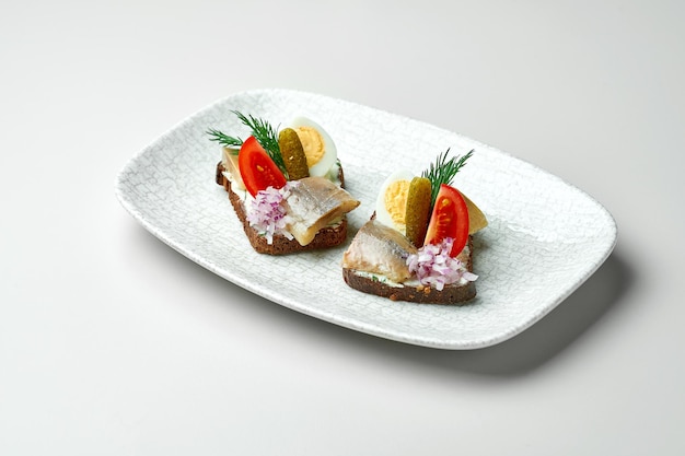 Smorrebrod or bread with herring on a white background