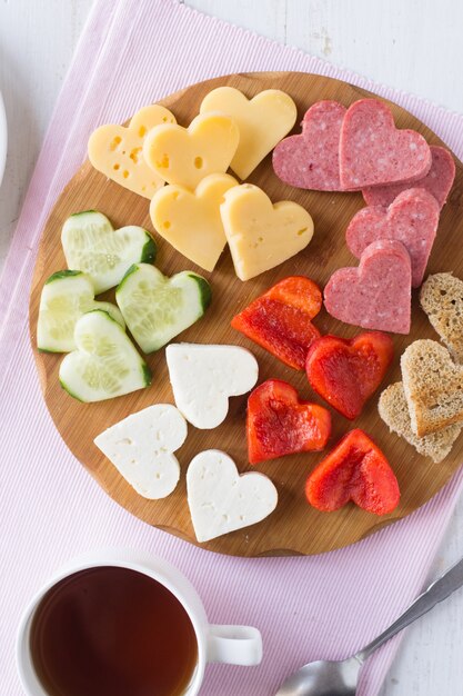 Snack board with cheese, red pepper, sausage, bread and cucumber