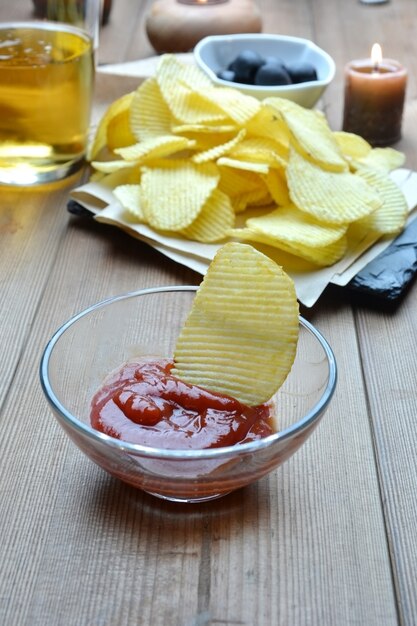 Snack chips and beer accompanied by olives