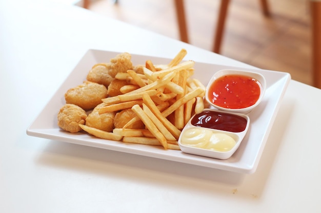 Snack plate nuggets en saus op een wit bord op een houten tafel