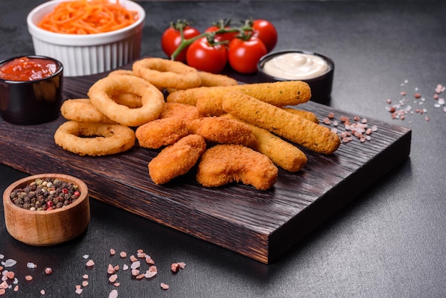 Snack platter  cheese sticks chicken nugget onion rings mix of snacks and sauces