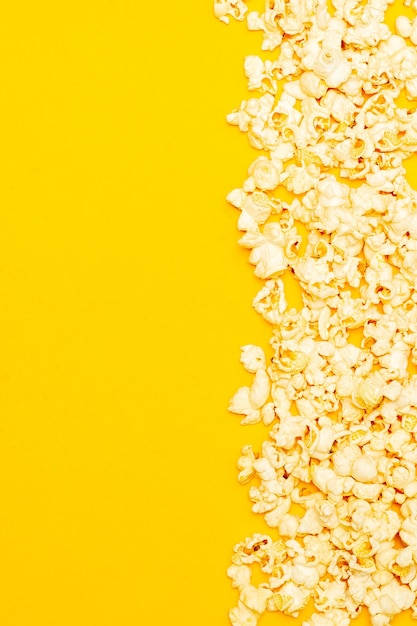 Snack van het kijken naar filmconcept Zoete popcorn opgestapeld op gele achtergrond