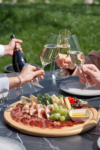 Snack voor gasten Een bord kaas salami noten druiven en snacks op een dienblad