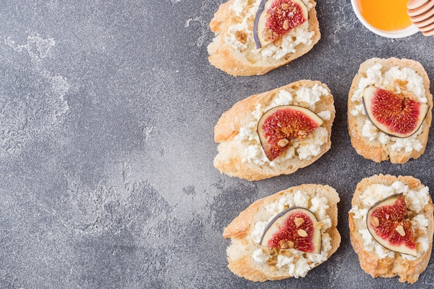 Snacks bruschetta with cottage cheese, walnut and honey and figs