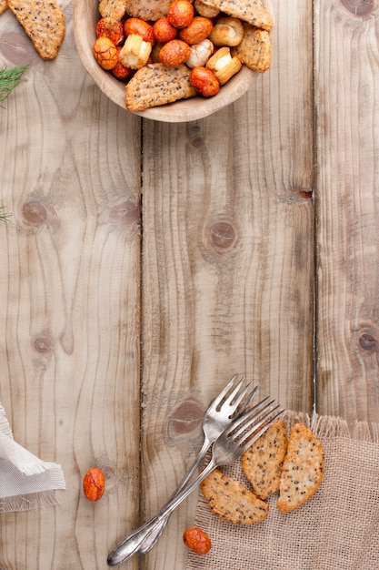 snacks en beschuit in een beker, vorken, op een houten achtergrond