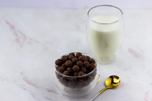 Snacks in de vorm van chocoladeballen Een kom met een snel ontbijt, een glas melk en de inscriptie liefde op een witte marmeren achtergrond