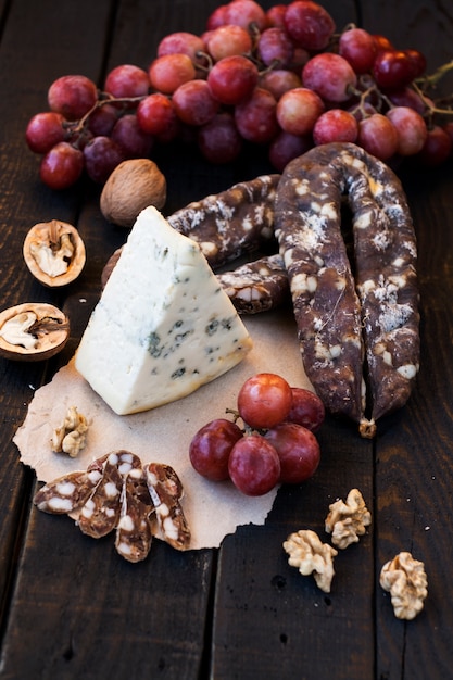 Snacks voor wijn, kaas met schimmel, roze druiven, walnoten en geroosterde droge worst