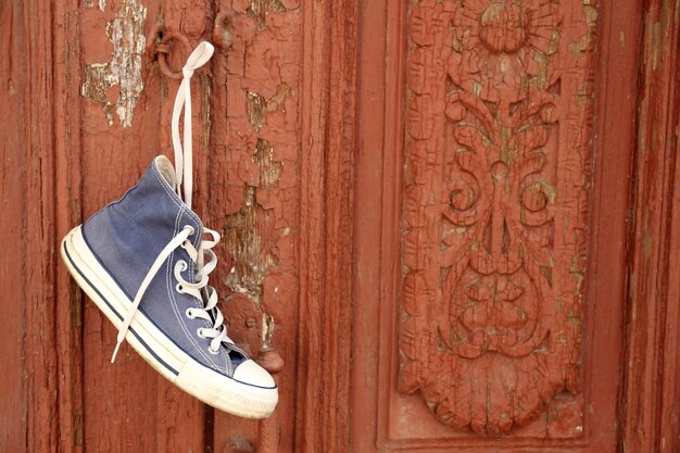 Sneaker hanging on wooden door