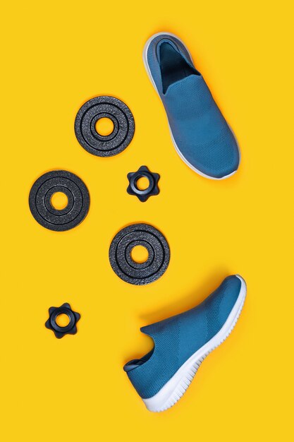 Sneakers and kettlebells on yellow.