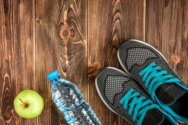 Sneakers, water and apple with headphones