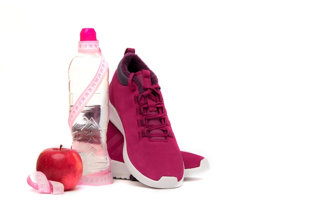 Sneakers, water en fruit op wit.