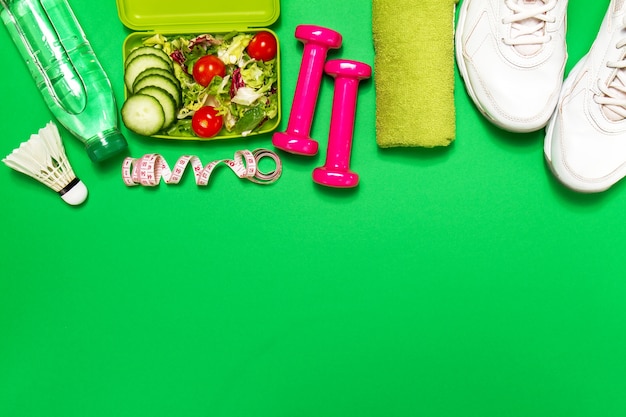 Sneakers with a salad and pink dumbbells