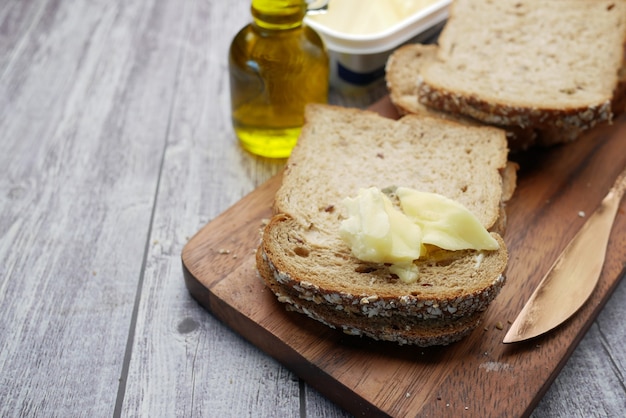 Sneetje boter en volkoren brood op snijplank