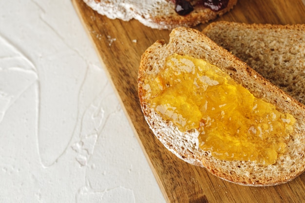 Sneetje brood bedekt met fruitjam op een houten bord