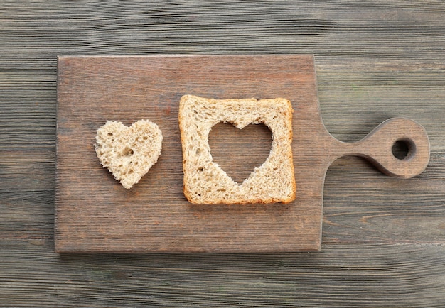 Sneetje brood met gesneden in de vorm van een hart op houten achtergrond