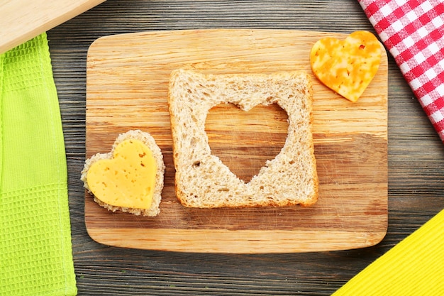 Sneetje brood met gesneden in de vorm van hart en kaas op tafel close-up