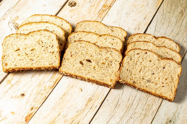 Sneetjes volkoren brood met ontbijtgranen op houten tafel