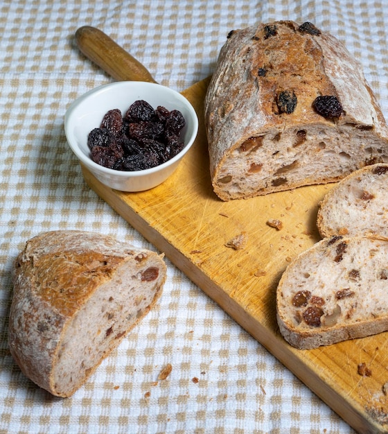 Sneetjes zelfgebakken brood met rozijnen, noten en gedroogd fruit op houten plank