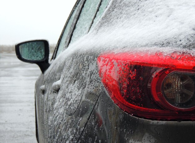 Sneeuw bedekt de achterlichten van de auto op de bevroren weg