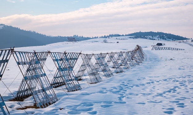 Foto sneeuw bedekte hek door besneeuwde berg tegen de lucht