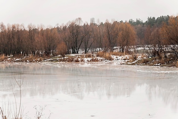 Sneeuw en ijs smelten op een meer in de bosbron