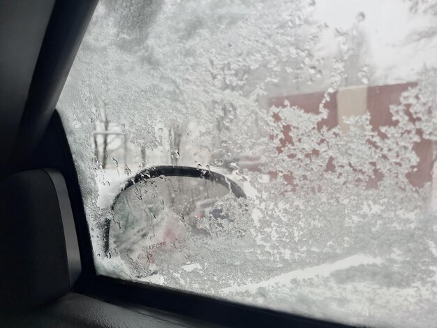 Sneeuw op zijruiten en uitzicht vanuit de auto