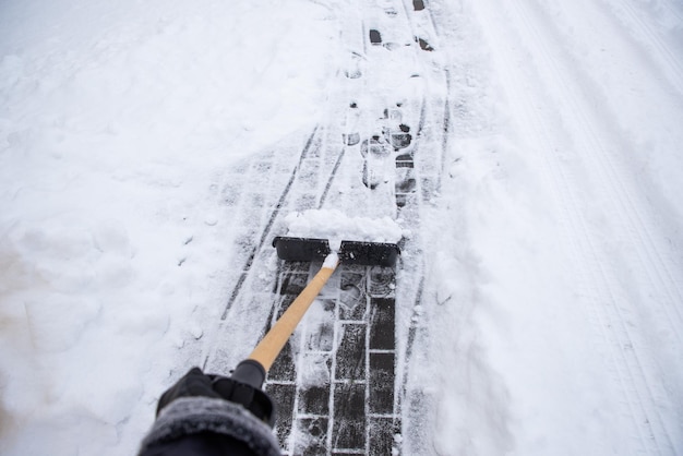 Sneeuw opruimen van de stoep.