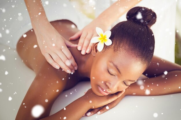 Foto sneeuw tegen close-up van een mooie vrouw op een massagetafel