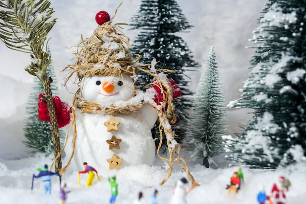 Sneeuwman en mensen in dennenbossen tijdens de winter