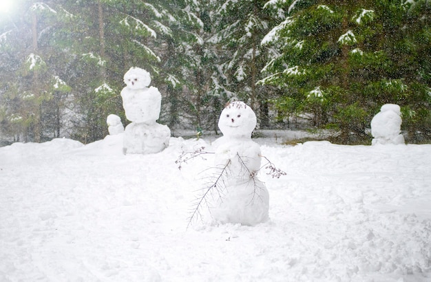 Sneeuwpop bij elkaar geplakt in het bos Lachende familie sneeuwmannen koude winter behang