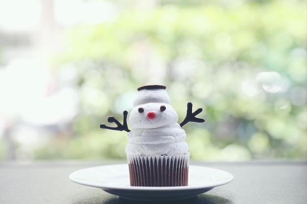 Sneeuwpop cupcake op groene achtergrond