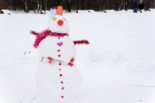 Sneeuwpop staande op de achtergrond van witte sneeuwbanken in het winterlandschap. Heel veel sneeuw. Sneeuw vrouw.