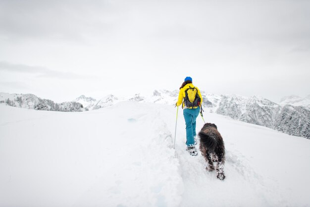 Sneeuwschoenwandelen in de bergen een alleenstaande vrouw met haar geliefde hond