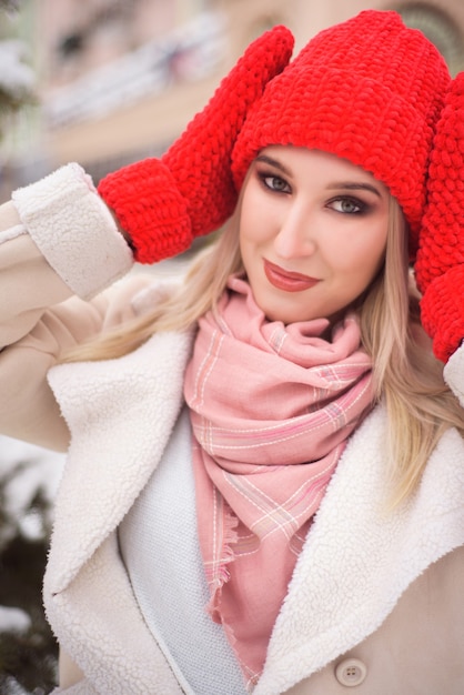 Foto sneeuwval vrouw stad kerst buiten, stadsportret in sneeuwval, jong model poseren in feestelijke look.