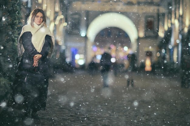 sneeuwval vrouw stad kerst buiten, stadsportret in sneeuwval, jong model poseren in feestelijke look