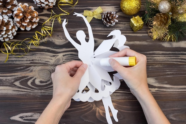 Sneeuwvlok ballerina papier. Stap-voor-stap foto instructie. Doe-het-zelf-concept. Kerst- en nieuwjaarsambachten voor kinderen. Stap 12.