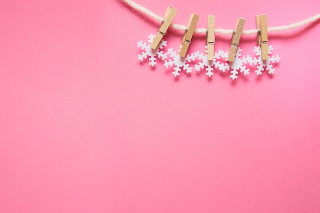 Foto sneeuwvlokken aan een touw op roze