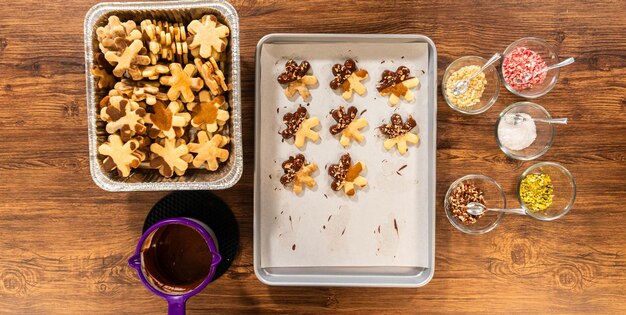 Foto sneeuwvlokkenvormige suikerkoekjes, chocolade, pecan, gekneusde noten, feestbakken.