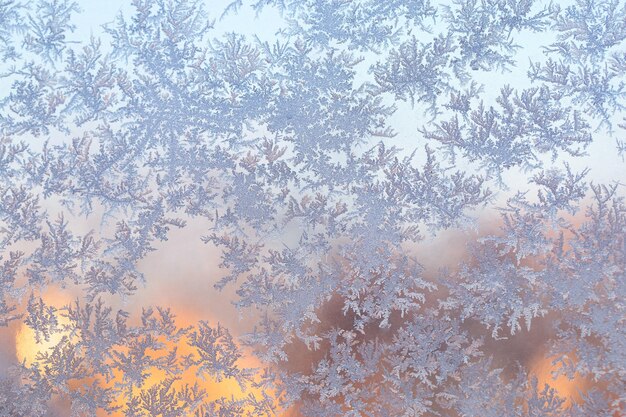 sneeuwvorst in de vorm van natuurlijke patronen op de ruit tegen de achtergrond