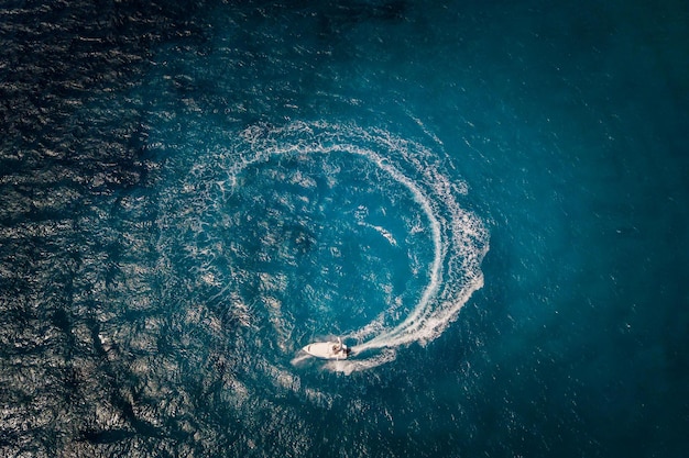 Snelheidsmotorboot die cirkel creëert op zee Luchtfoto van een drone