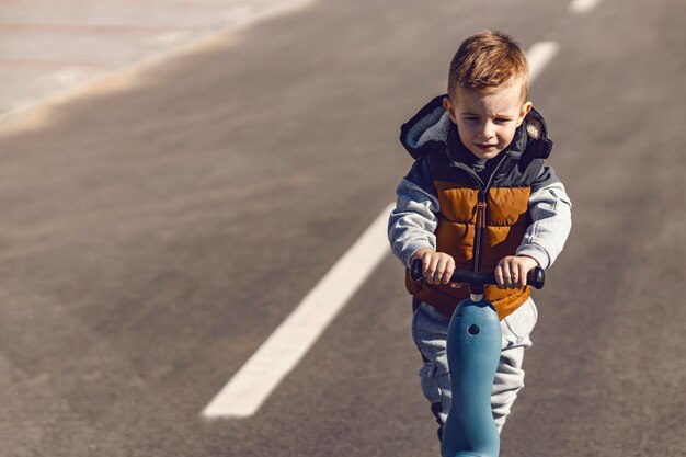 Snelle kleine jongen rijdt scooter op straat