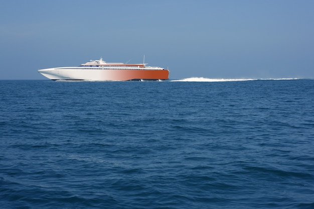 Snelle veerboot die blauw oceaan overzees wit kielzog vaart