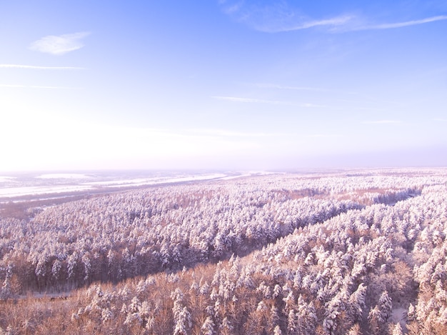 Snelweg door het winterbos Luchtfoto op weg en rivier op achtergrond Blauwe lucht