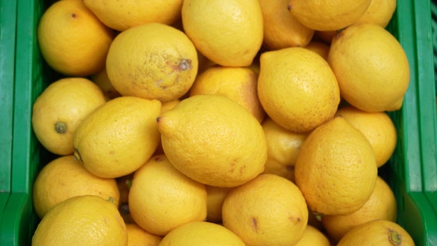 Snelwegen van containers met rijpe citroenen van fruit in de voedselpassage in de supermarkt natuurlijk fruit voor een gezond dieet videocitrusvruchten als concept van gezond dieet