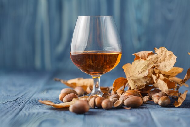 Snifter of brandy and dried oak leaves