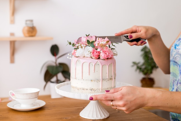 Snij de cake. Close-up van de handen die van vrouwen de cake met een mes snijden.