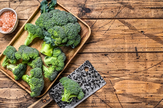 Foto snijd broccoli in een bakje. houten achtergrond. bovenaanzicht. kopieer ruimte.
